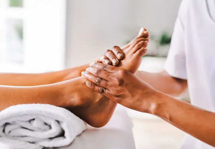Mani esperte eseguono riflessologia plantare, un tocco di benessere per alleviare la depressione e ritrovare l'equilibrio.