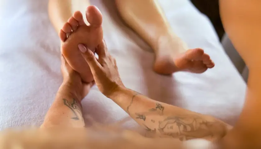 Mani esperte eseguono riflessologia plantare. Scopri i riflessologia plantare costi per un benessere totale.