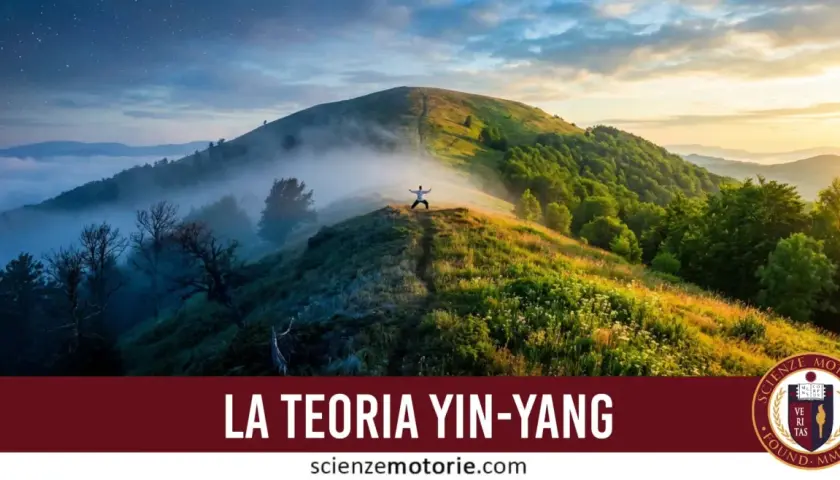 A person in a white shirt stands with arms outstretched on a misty mountain ridge at sunrise.