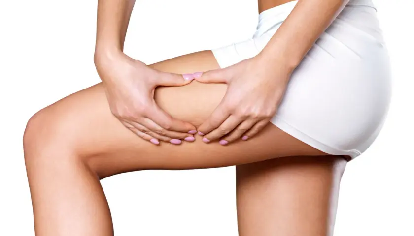 Woman's hands pinching thigh, showing skin texture.