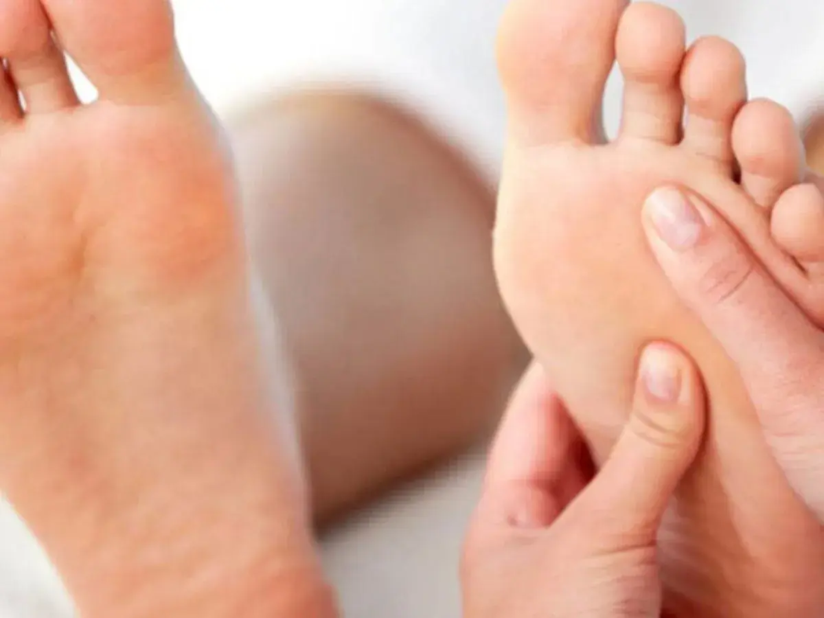 Close-up of hands massaging the sole of a foot.