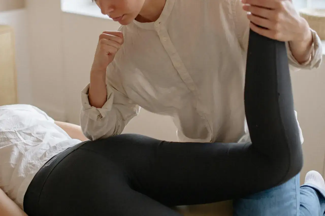 Un terapista esegue un massaggio glutei con un gomito, aiutando a sciogliere la tensione muscolare.
