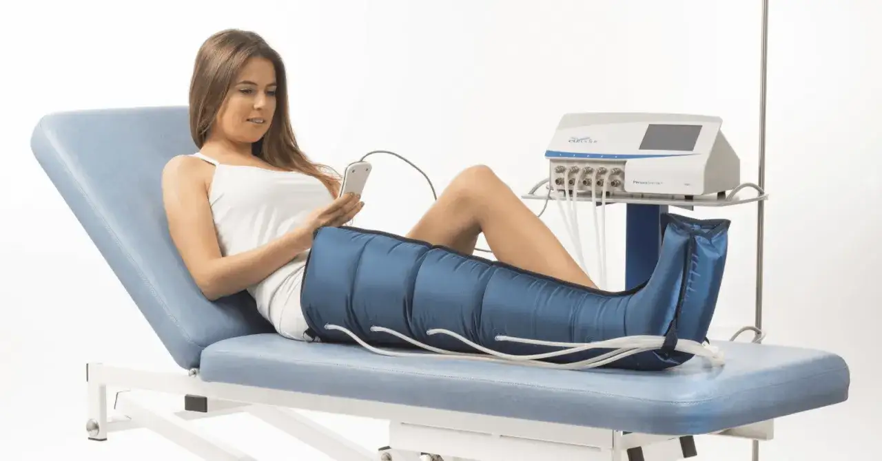 Donna sdraiata su lettino con gambe in manicotto per pressomassaggio cos'è. Dispositivo medico per drenaggio linfatico.