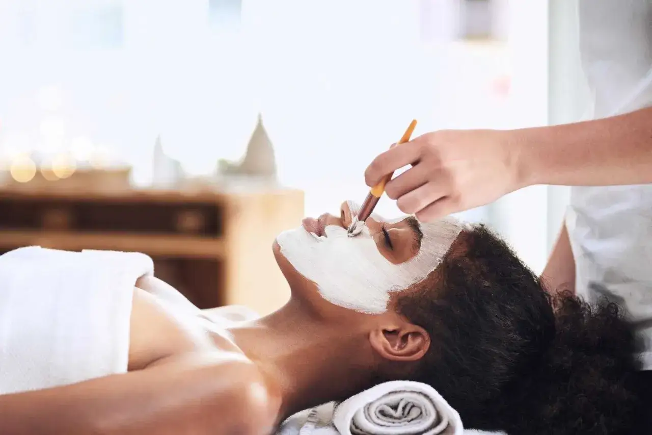 Donna riceve un trattamento viso purificante, parte di trattamenti detox per un relax totale.